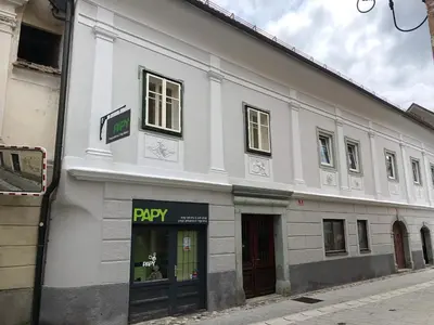 a large white building with a pay sign on it at Apartma Linhartov trg in Radovljica