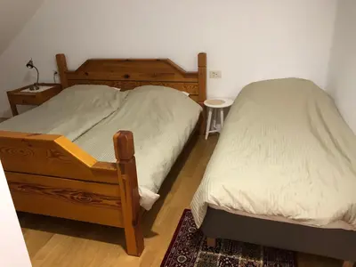 a bedroom with two twin beds and a table at Apartma Linhartov trg in Radovljica