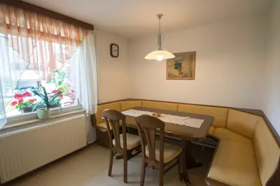 a dining room with a table and chairs and a window at apartma mojca in Bohinj