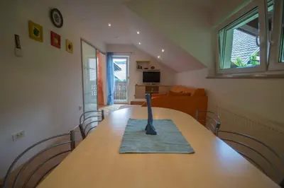 a dining room table with a vase on top of it at apartma mojca in Bohinj