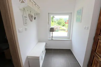 a small white room with a window and a toilet at Adventure Cottage with pool and big garden in Bled
