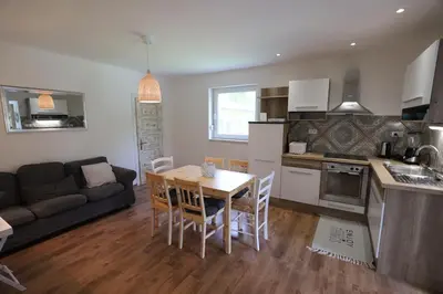 a kitchen and living room with a table and chairs at Adventure Cottage with pool and big garden in Bled