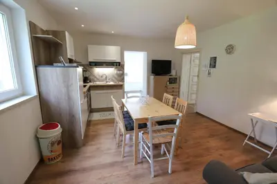 a kitchen and dining room with a table and chairs at Adventure Cottage with pool and big garden in Bled