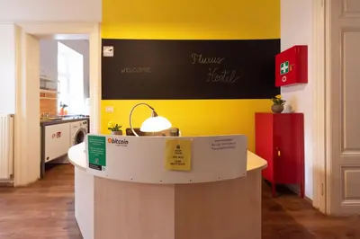 a kitchen with a counter with a yellow wall at Fluxus Hostel in Ljubljana