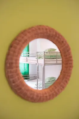 a mirror reflecting a room with a bunk bed at Fluxus Hostel in Ljubljana