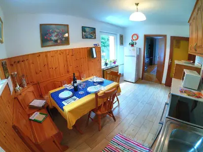 a kitchen with a table with chairs and a kitchen with a tableablish at Apartment and Garden house among the mountains in Podbrdo