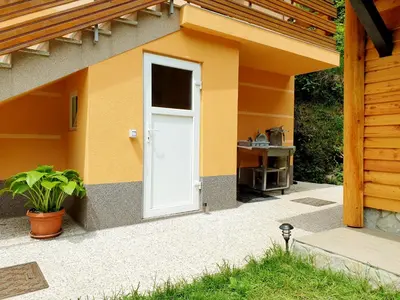 a white door on the side of a house at Apartment and Garden house among the mountains in Podbrdo