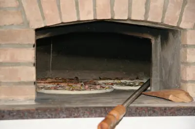 a pizza oven with two pizzas in it at Hotel Rakitna in Rakitna