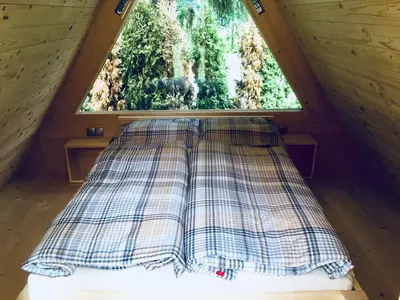 a bed in a tiny house with a window at Glamping houses J-Max in Bled