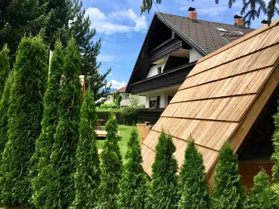 a house with a wooden fence and trees at Glamping houses J-Max in Bled