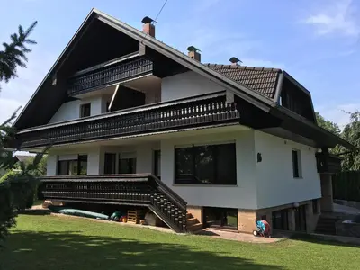 a white house with a black roof and stairs at Glamping houses J-Max in Bled