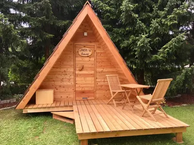 a wooden cabin with two chairs and a table in it at Glamping houses J-Max in Bled