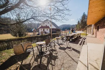 a group of tables and chairs in front of a building at Farm stay Žurej in Šentjur