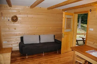 a log cabin with a couch in the living room at Gorska hiška Vogar nad Bohinjskim jezerom in Bohinj
