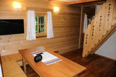 a room with a wooden table in a cabin at Gorska hiška Vogar nad Bohinjskim jezerom in Bohinj