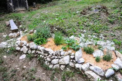 a garden with rocks and plants in a yard at Gorska hiška Vogar nad Bohinjskim jezerom in Bohinj