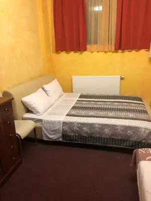 a small bedroom with a bed and a dresser at Motel Sofia in Sežana