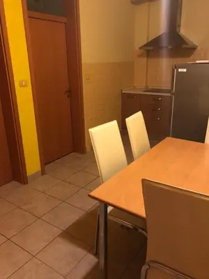 a kitchen with a wooden table and white chairs at Motel Sofia in Sežana