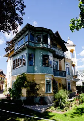 a large yellow and green house with a balcony at Vila Ana Generoes Bled in Bled
