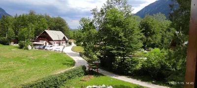 a house in a field next to a road at Apartments Lake Bohinj in Bohinj