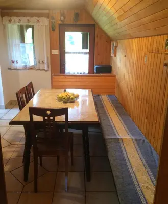 a dining room with a wooden table and chairs at Mountain apartment Uskovnica in Bohinj