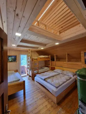 a bedroom with two bunk beds in a cabin at Mountain apartment Uskovnica in Bohinj