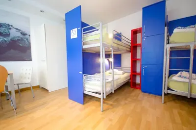 a room with three bunk beds and a table at H2O Hostel in Ljubljana