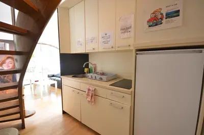 a kitchen with white cabinets and a refrigerator at H2O Hostel in Ljubljana