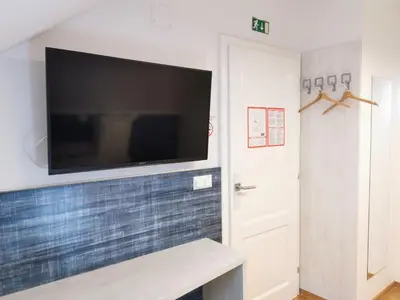 a living room with a tv on a wall at H2O Hostel in Ljubljana