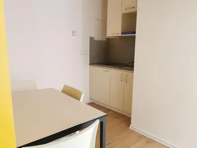 a kitchen with a white table and a white counter top at H2O Hostel in Ljubljana