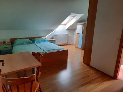 a bedroom with a bed and a table and a kitchen at Tourist Farm Lavrič in Woditz