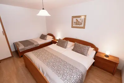 a bedroom with two beds in a room at Apartments & Rooms Malej in Bohinj