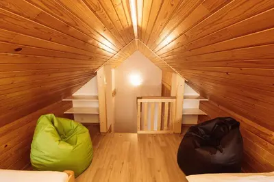 a room with a large wooden ceiling with two bean bags at Apartments & Rooms Malej in Bohinj