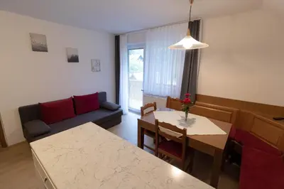 a living room with a table and a couch at Apartments & Rooms Malej in Bohinj