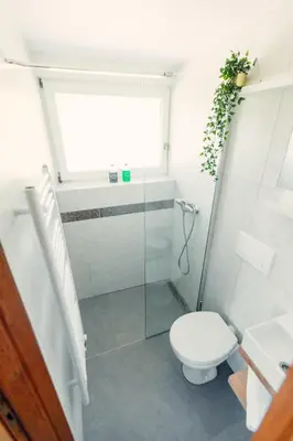 a bathroom with a toilet and a glass shower at Frankovič Bed&Breakfast in Vinica