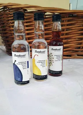 three bottles of alcohol sitting on a table at Frankovič Bed&Breakfast in Vinica