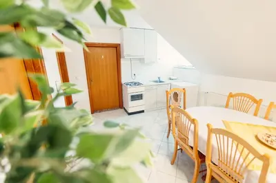 a kitchen and dining room with a table and chairs at Frankovič Bed&Breakfast in Vinica
