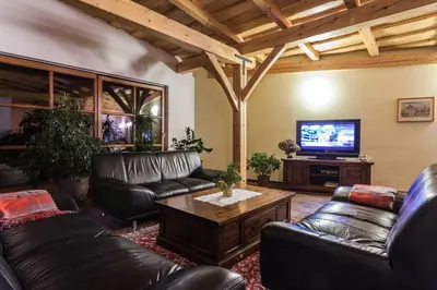 a living room with leather furniture and a flat screen tv at Tourist Farm Zelinc in Cerkno