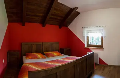 a bedroom with a large bed with red walls at Holiday House Vodice na Lazu in Zoll