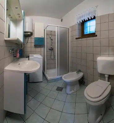 a bathroom with a toilet and a sink and a shower at Holiday House Vodice na Lazu in Zoll