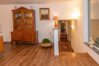 a living room with a wooden cabinet and wooden floors at Apartma Spaans in Radovljica