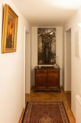 a hallway with a wooden cabinet and a painting on the wall at Apartma Spaans in Radovljica
