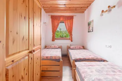 two twin beds in a room with a window at APARTMA KOŠNIK in Bohinj