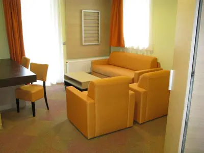 a living room with a couch and a chair and a table at Hotel Center Pokljuka in Goreljek