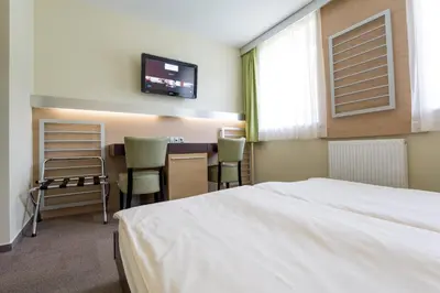 a bedroom with a bed and a desk with chairs at Hotel Center Pokljuka in Goreljek