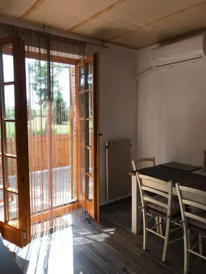 a dining room with a table and a sliding glass door at Apartma, Prekmurska vas, Trobentica 32 in Moravske Toplice