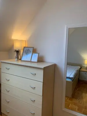 a dresser with two pictures on it next to a mirror at Apartma, Prekmurska vas, Trobentica 32 in Moravske Toplice