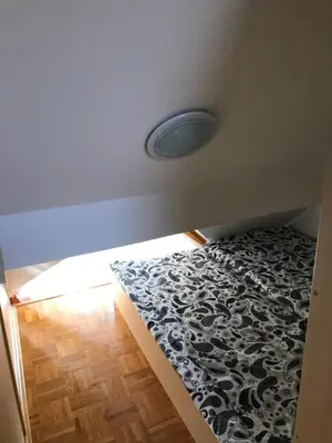 a bedroom with a bed with a black and white comforter at Apartma, Prekmurska vas, Trobentica 32 in Moravske Toplice
