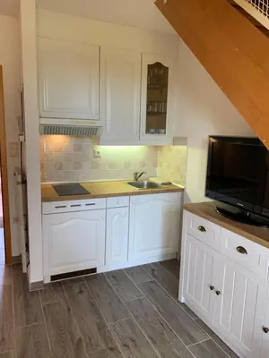 a kitchen with white cabinets and a sink and a microwave at Apartma, Prekmurska vas, Trobentica 32 in Moravske Toplice