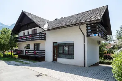 a white house with a black roof at Apartment Kolman in Bohinj